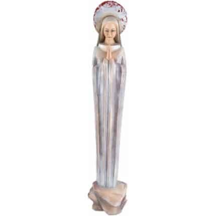 Viktor-Art La Madonna - Cielo de Plata - en las rocas es una estatua en bajorrelieve de madera tallada a mano de una mujer serena con túnicas fluidas, con las manos unidas en oración y un halo redondo y texturizado con acentos rojos, de pie sobre una base de tonos neutros similar a una roca. Talla exclusiva en madera