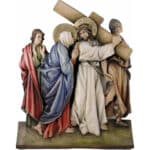 Viktor-Art Le chemin de croix (série 14 stations) - Polychrome est une sculpture en bois sculptée et peinte représentant Jésus portant la croix en robe blanche et couronne d'épines, soutenu par trois personnages dont Marie en bleu et rouge, représentant une scène religieuse émouvante. Sculpture en bois exclusive