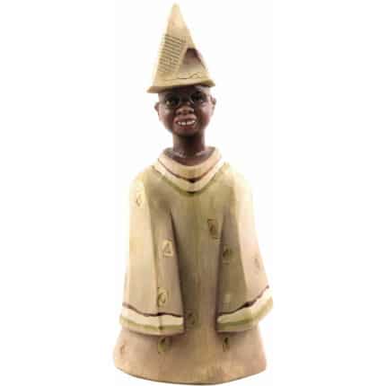Viktor-Art Wooden child/boy figurine (model 3 of 3): Hand-painted figurine depicting a smiling black child with round glasses, paper hat and loose beige robe with patches and brown stripes, with his hands tucked under his clothes. Exclusive Woodcarving